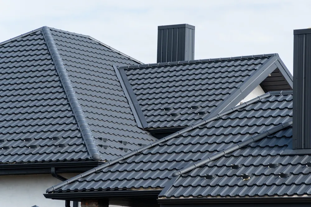 A close-up view of dark grey interlocking roof tiles featuring a modern, clean design.