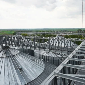 A high-angle industrial view looking down onto a complex structure of metal roofing or silos.